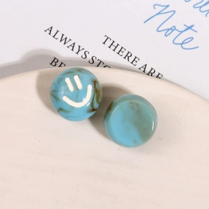 Macro detail of blue marble resin beads with a smiling face for jewelry making