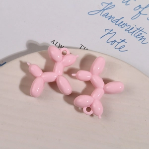 Detailopname van roze hars ballonhond hangers voor DIY handwerk op een keramische schaal