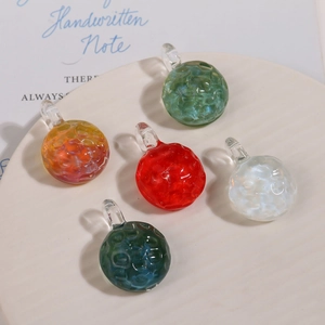 Close-up of textured glass sphere pendants with unique hammered finish for DIY jewelry