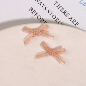 Detailed view of light pink organza fabric bows for DIY nail art and hair accessories