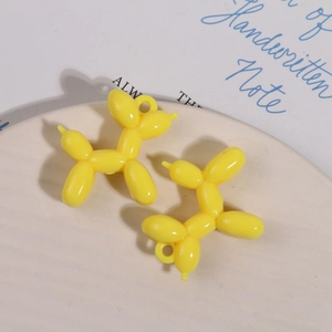 Detail van glanzende gele hars ballonhond hangers voor DIY sieraden en sleutelhanger crafts