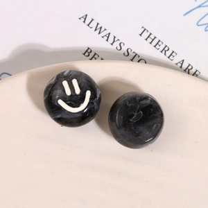 Detailed macro view of black and white marble resin beads featuring a cute smiley face design