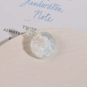 Macro shot of clear textured glass sphere pendant with hammer pattern and integrated loop