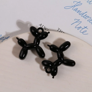 Detailopname van glanzende zwarte ballonhond-hangers voor DIY-sieraden en sleutelhangers