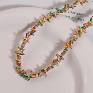 Primer plano de cuentas de estrella de colores con textura de pintura en plato blanco
