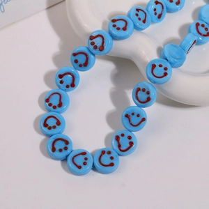Detailed macro of 14mm sky blue glass beads with red smiley faces for DIY jewelry making