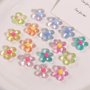Flat lay of colorful glitter resin five-petal flower charms for DIY hair accessories