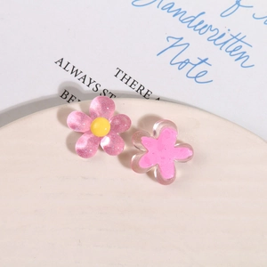 Macro detail of pink resin floral DIY accessories with glitter finish and yellow stamen