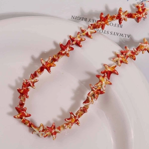 Primer plano de cuentas de estrella de mar rojas y amarillas con textura de óleo en plato