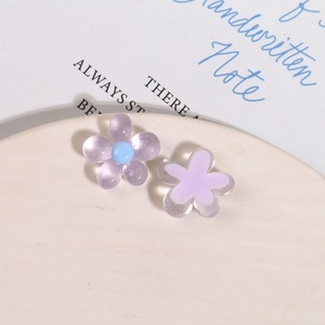 Detail of glitter resin flower charms for DIY hair clips on a ceramic plate