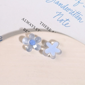 Close-up of glitter resin flower charms for DIY hair clips on a porcelain plate
