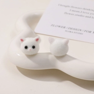 Detail von niedlichen weißen beflockten Katzenköpfen für DIY-Schmuck auf Herztablett