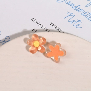 Detailed macro view of resin five-petal flower charms with glitter and cat eye texture