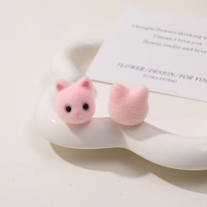 Nahaufnahme von rosa beflockten Katzenkopf-Charms aus Harz für DIY-Ohrringe und Bastelarbeiten