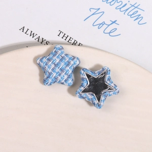 Detailed view of star-shaped blue tweed fabric buttons with metallic silver backing