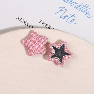 Close-up of pink tweed star-shaped fabric charms with metal base for DIY accessories