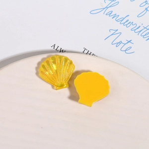 Dettagli macro di ciondoli in resina a conchiglia gialla sfumata per creazione gioielli