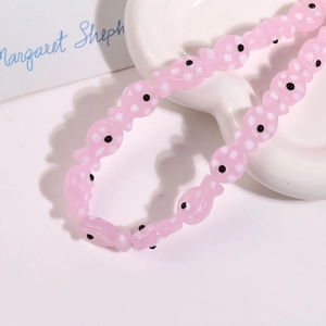 Macro shot of pink ceramic fish beads with white polka dots for DIY jewelry making
