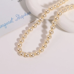 Détail de perles d'imitation rondes blanc crème de 10mm avec un lustre soyeux élégant