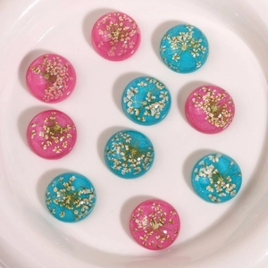 Macro detail of resin cabochons with real dried flowers and glitter for DIY jewelry