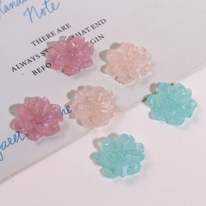 Detailansicht glitzernder Harz-Blumenanhänger in Rosa und Blau für DIY-Schmuckbasteln