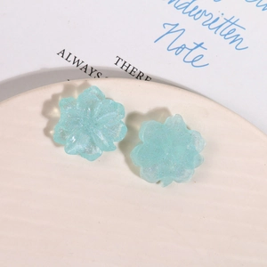 Makroaufnahme von hellblauen Harzblumen mit Glitzer für DIY-Ohrringe und Accessoires