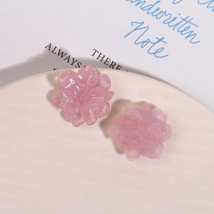 Makroaufnahme von rosa Harz-Blumenanhängern mit Glitzerfinish für DIY-Schmuck