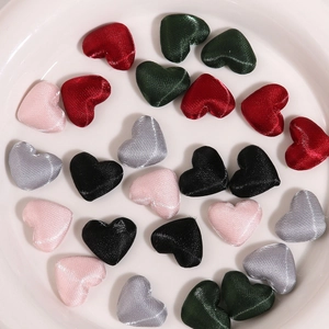 Macro detail of multicolored heart-shaped satin fabric patches for DIY accessories and crafts