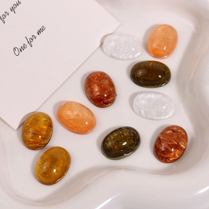 Macro view of oval resin cabochons with sand-like texture and cat-eye effect shimmer