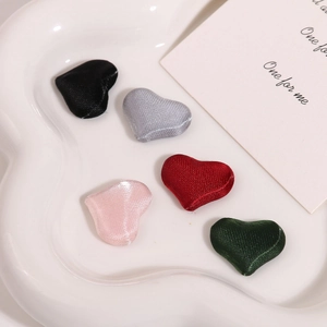 Close-up of heart-shaped fabric buttons in five colors for DIY jewelry making