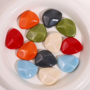Detailed macro view of colorful triangular resin charms for DIY earrings and hair accessories