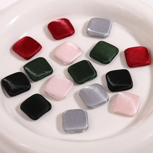 Detail of square fabric covered buttons with satin texture in multiple vibrant colors