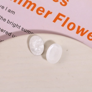 Macro shot of oval white pearlescent resin pendants with smooth seashell texture for DIY