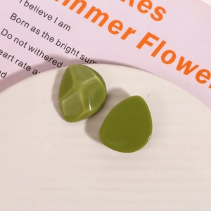 Macro view of olive green resin earrings with irregular geometric shapes and glossy finish