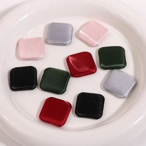 Close-up of geometric fabric-covered square buttons in five assorted silk-textured colors