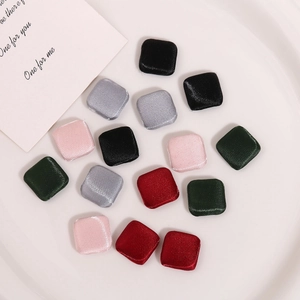 Close-up of assorted glossy fabric square buttons in various colors for DIY sewing crafts