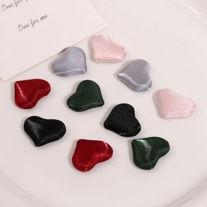 Macro shot of 3D padded satin heart patches in various colors for DIY craft decoration