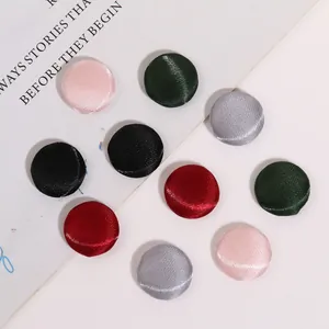 Dettaglio di bottoni rotondi rivestiti in raso colorato con trama di seta liscia
