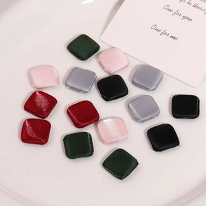 Macro detail of colorful square fabric covered buttons on a white ceramic plate