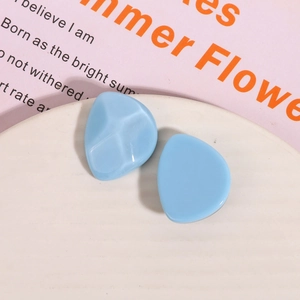 Macro shot of sky blue irregular resin studs on a textured white display tray
