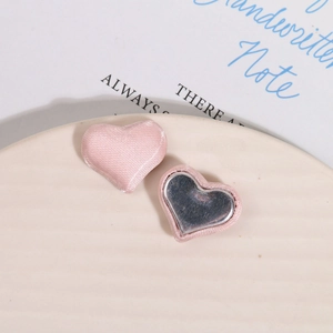 Detail view of pink satin heart buttons for DIY jewelry with magnetic metal backing