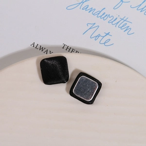 Detail of square black silk fabric covered buttons with silver metal backings for DIY