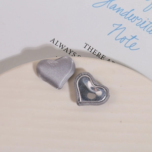 Detailed macro view of heart-shaped fabric buttons with woven texture and metallic centers