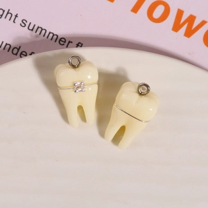 Dettaglio di ciondoli a dente 3D in resina con apparecchio argentato per gioielli fai-da-te
