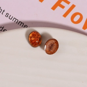Macro detail of oval amber resin cabochons with gold foil texture for DIY jewelry making