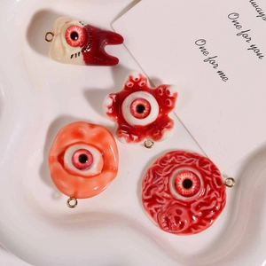Macro detail of gothic horror resin pendants with bloodshot eyes and realistic teeth design