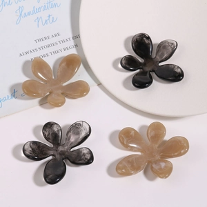 Detailed macro view of irregular resin flowers with ink wash texture for hair claw clips