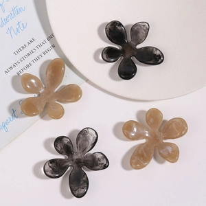 Macro detail of irregular ink-wash resin flower charms for DIY hair accessories