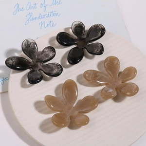 Detail view of irregular resin flower accessories with marble ink pattern on display