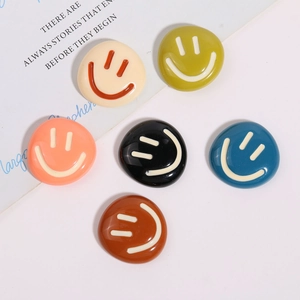 Macro view of six colorful smiley face resin charms for DIY hair clips and phone cases